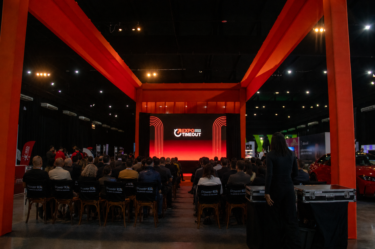 Arena Expo com palco de palestras temáticas iluminado durante sessão